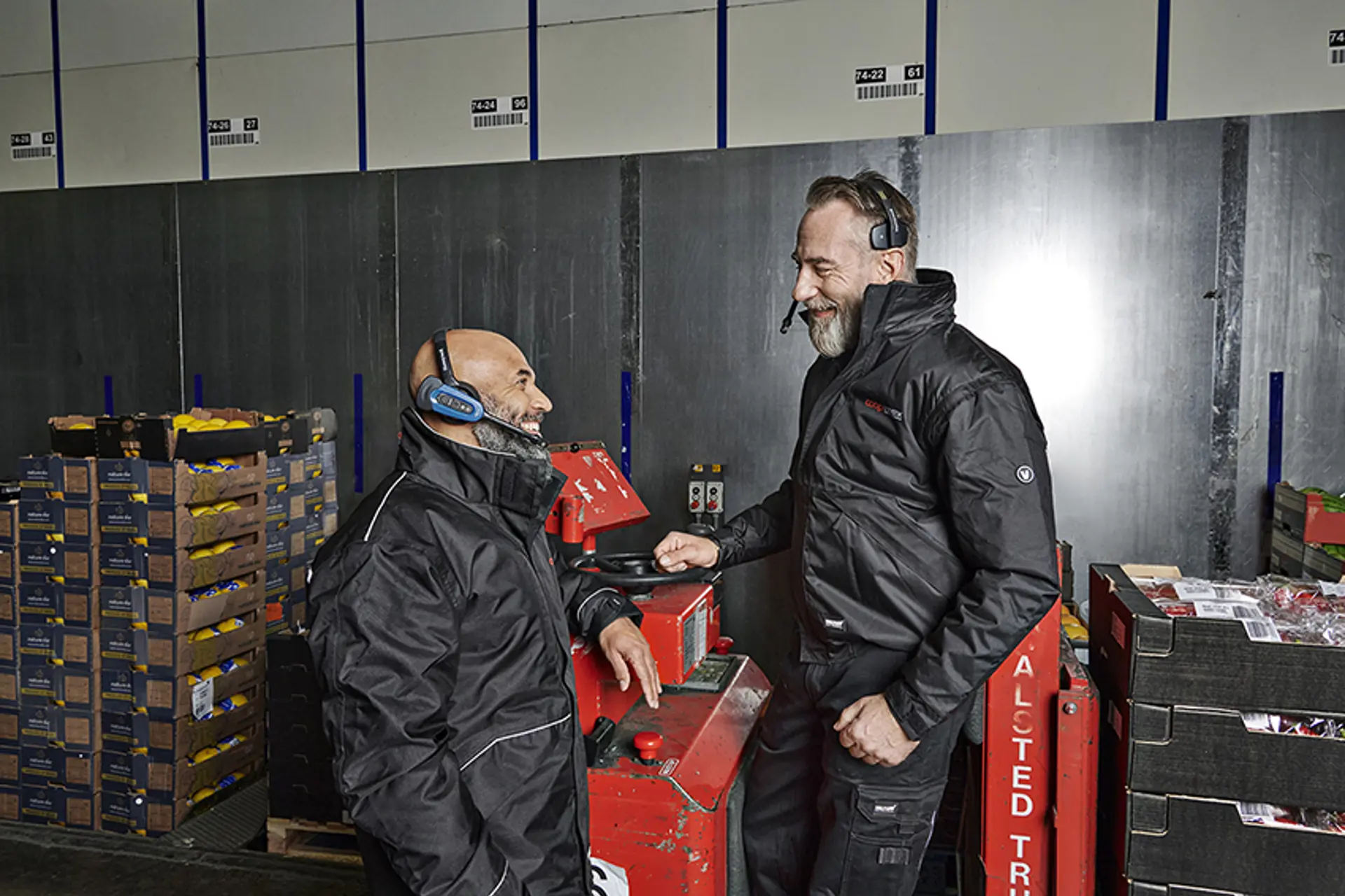 Medarbejdere i snak foran truck på lager